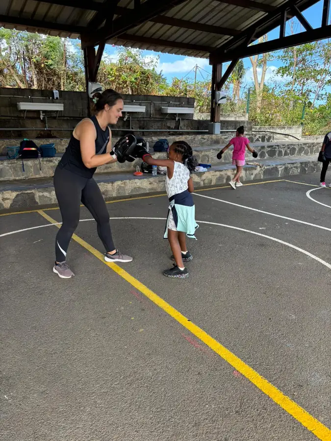 Boxe éducative : une élève frappe dans les pattes d'ours tenues par une intervenante